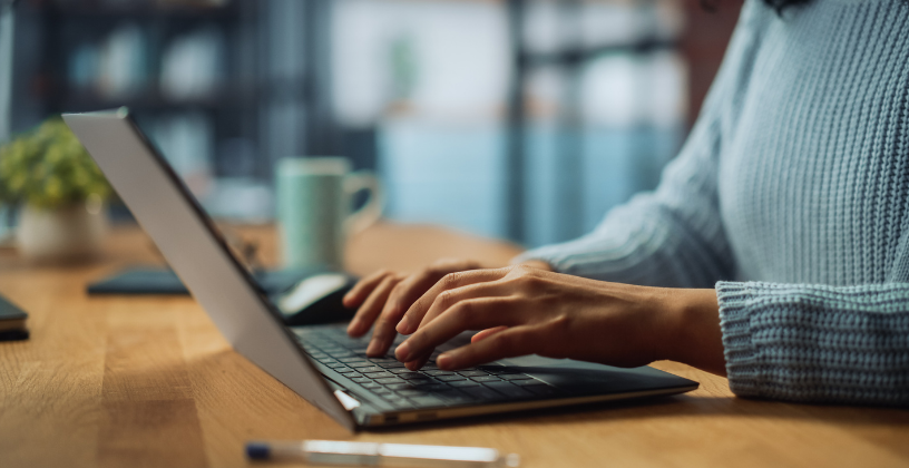 Benefit 2_ An AVETMISS-Ready LMS Simplifies Reporting Person using a laptop to manage AVETMISS reporting for an Australian RTO