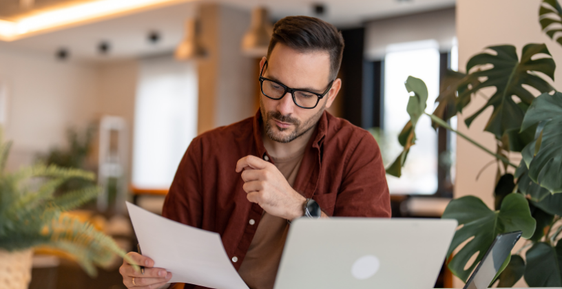 Professional reviewing training compliance documents on a laptop for an Australian RTO