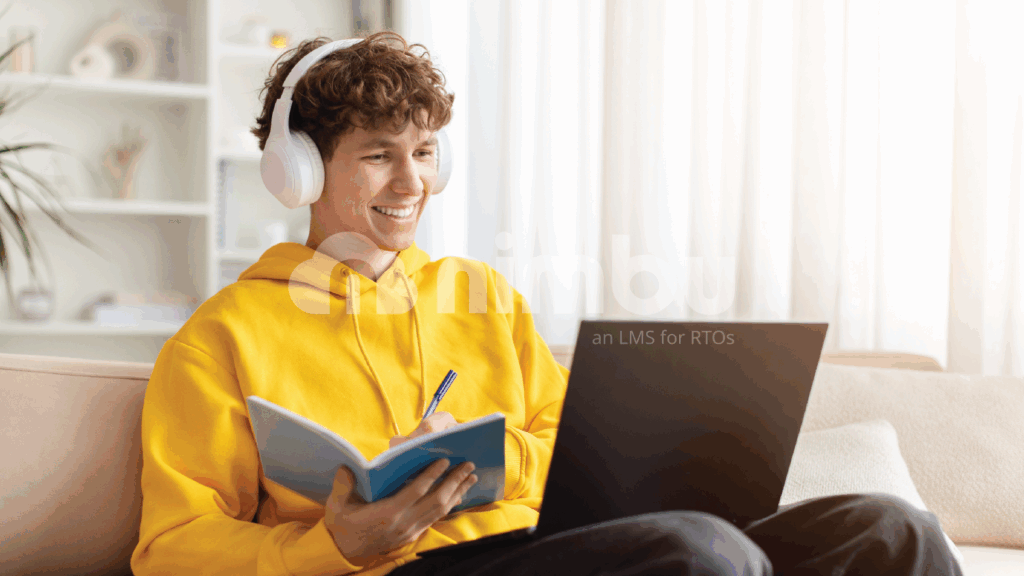 Student attending an online class from home, taking notes while learning on a laptop with headphones.