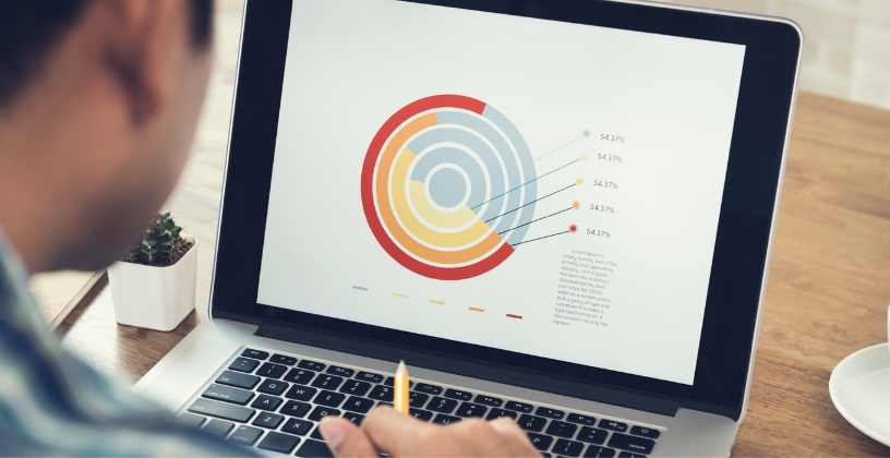 Man focused on a laptop displaying a colorful pie chart, analyzing data for a project or presentation.